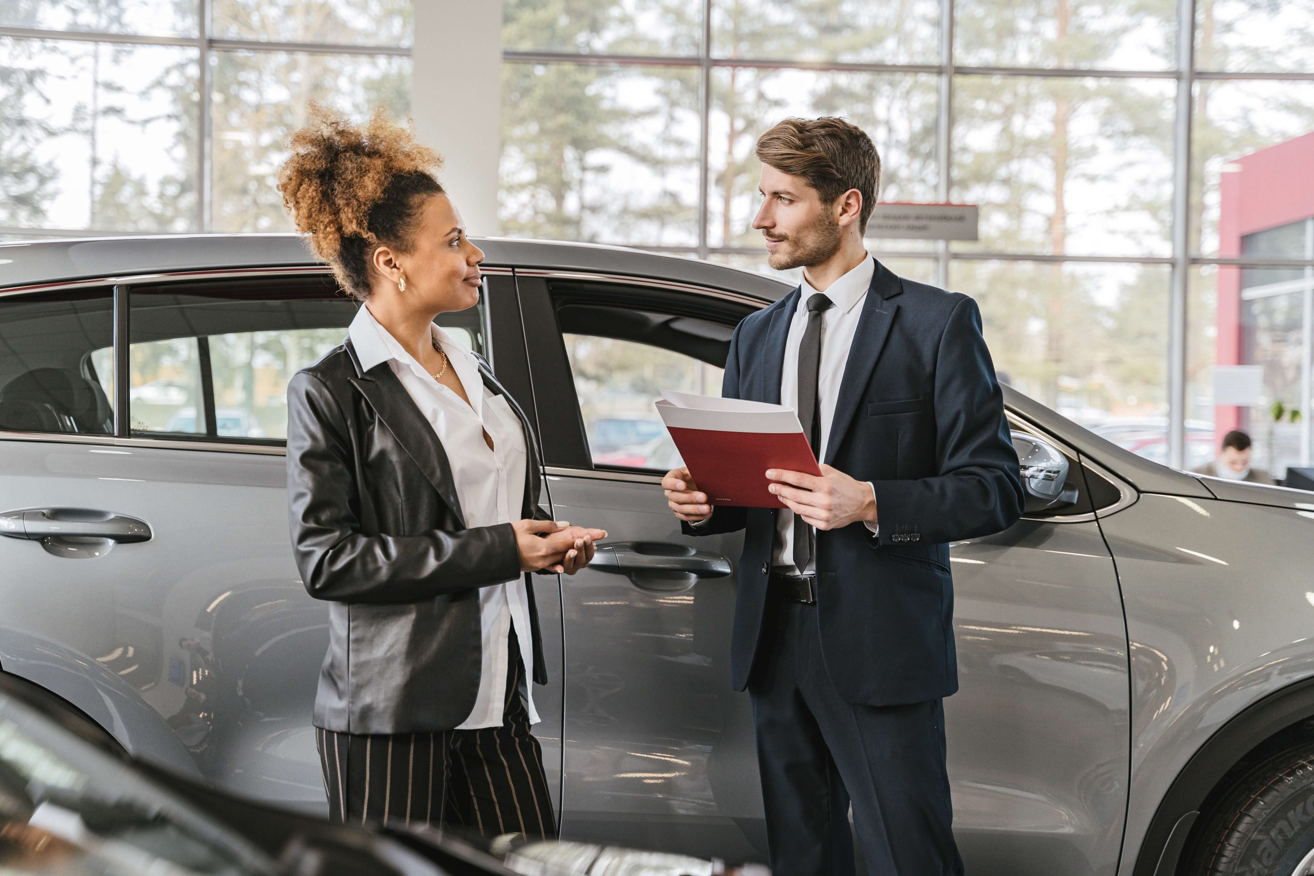 personas firman en concesionario contrato de compraventa coche